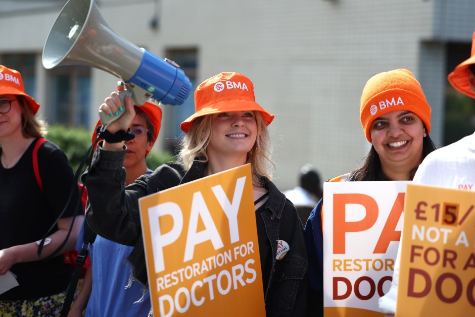 a woman holding a sign that says pay restoration for doctors