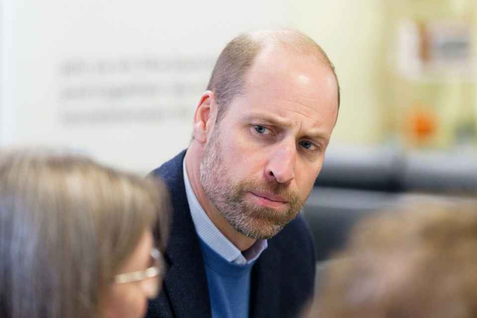 a bald man with a beard is talking to a woman