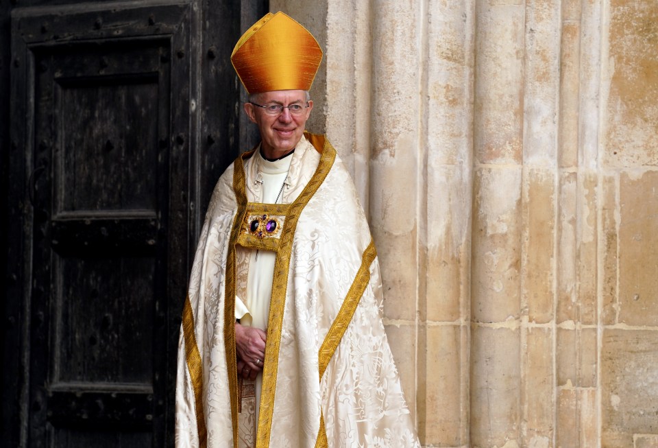 a man in a white robe and a yellow hat stands in front of a door