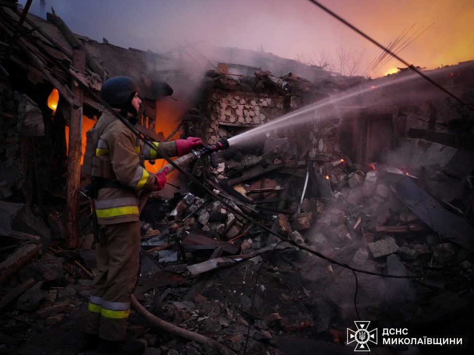 The site of a blast in Mykolaiv – one of the worst hit regions – as a firefighter works to put out flames