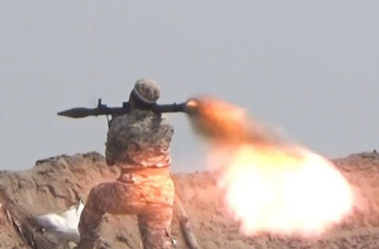 a soldier is holding a rocket launcher and firing it in the air .