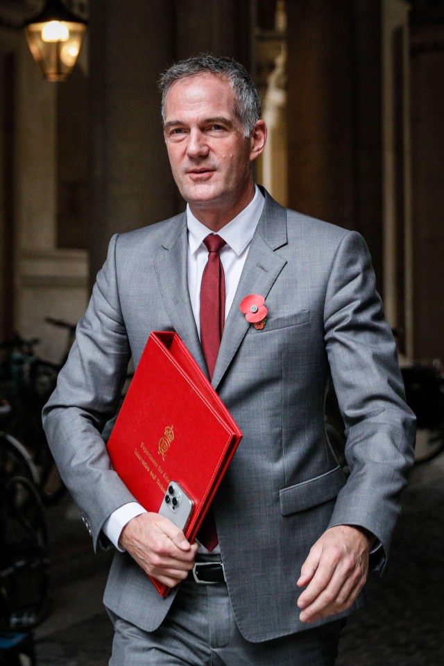 a man in a suit and tie is holding a red folder that says ' secretary of state ' on it