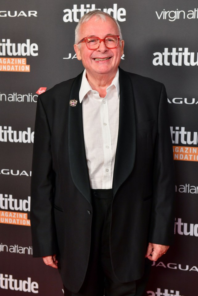 a man in a tuxedo stands in front of a sign that says attitude