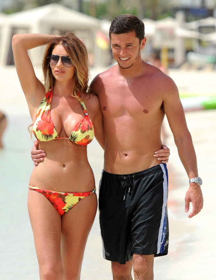 a woman in a bikini stands next to a man in black shorts