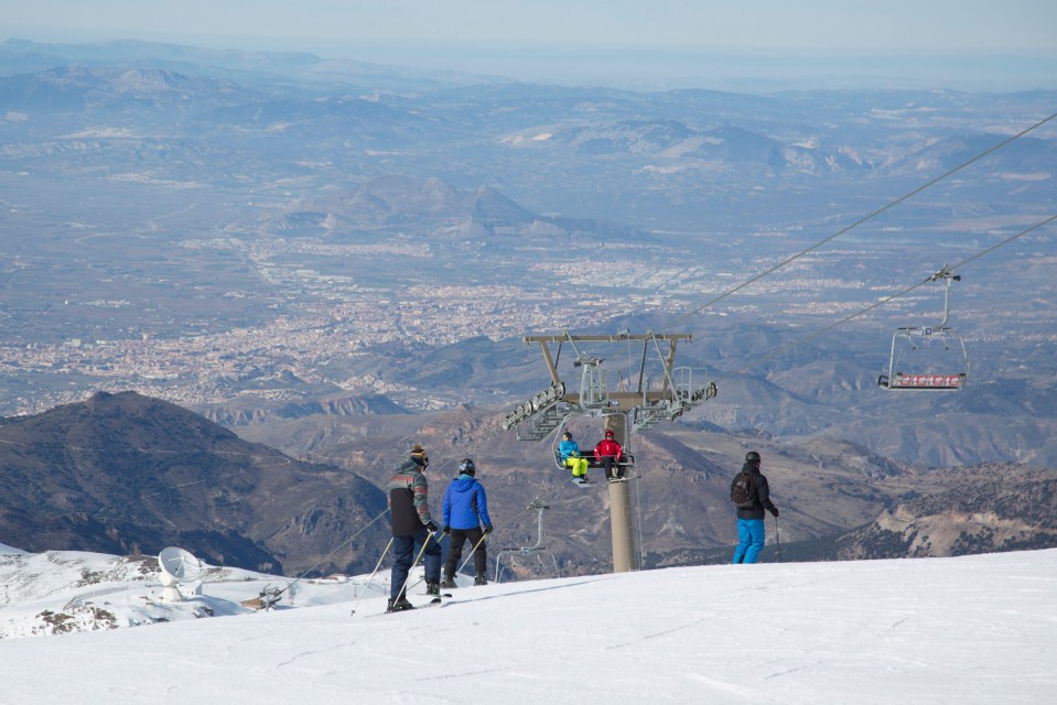 skiers on a ski lift with a sign that says ' coca cola ' on it