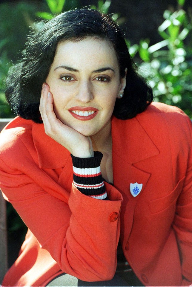 a woman wearing a red jacket has a pin on her sleeve