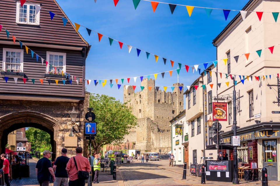 people walking down a street in front of a sign that says ' castle ' on it