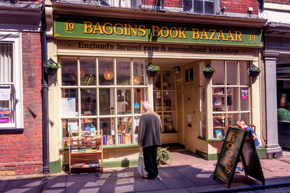 a man stands in front of the baggins book bazaar