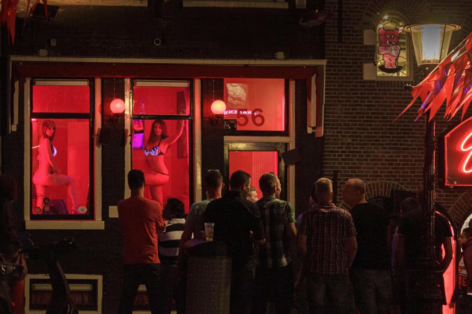 A group of men watch sex workers in a red light district