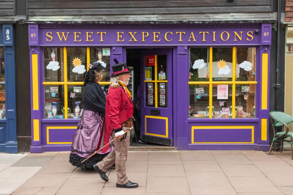 a couple walking in front of a store called sweet expectations