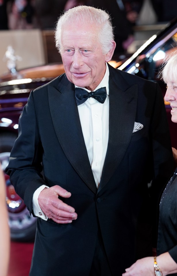 a man in a tuxedo is standing in front of a crowd