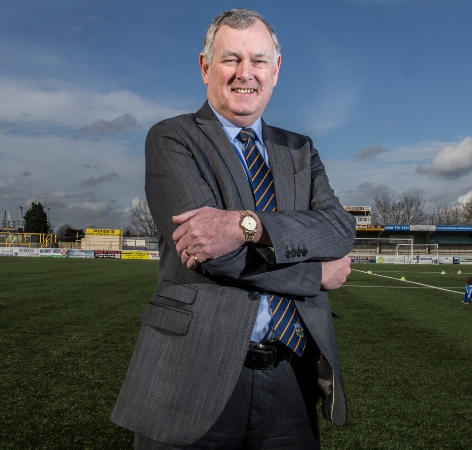 a man in a suit and tie stands on a soccer field