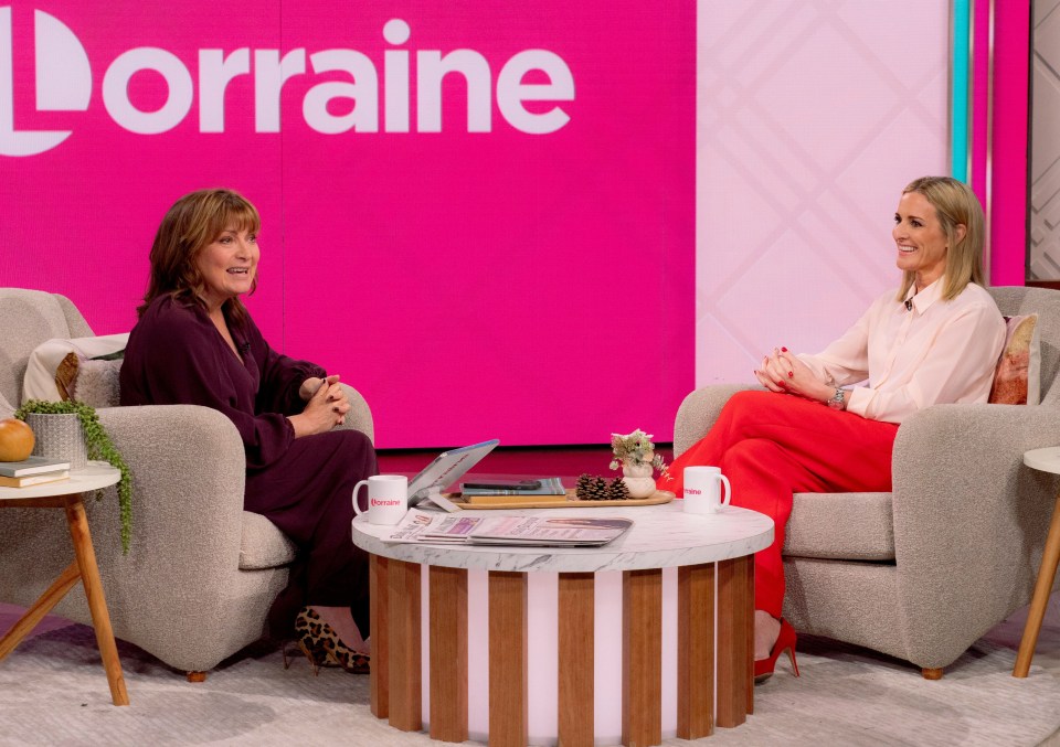 two women sit at a table in front of a sign that says lorraine