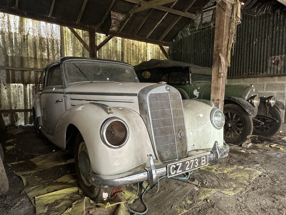 Two rare cars have sold at an auction after being hidden away in a barn for 40 years