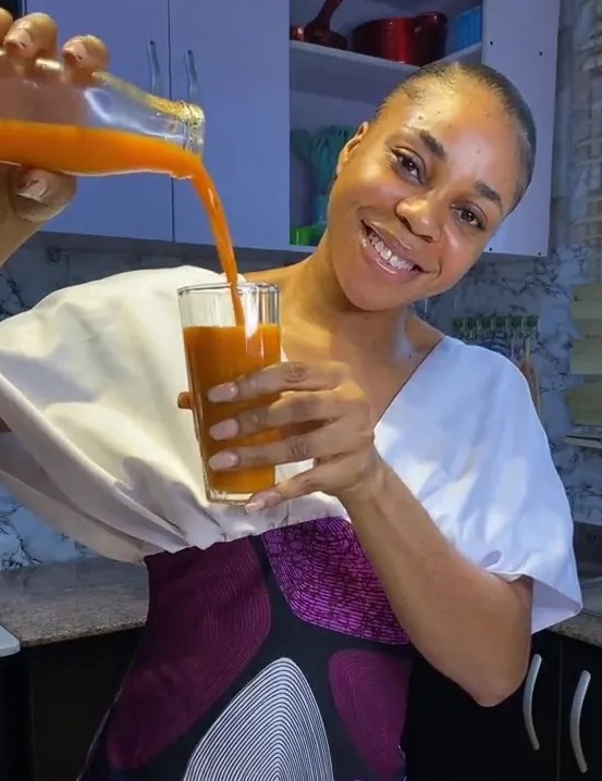 a woman is pouring orange juice into a glass