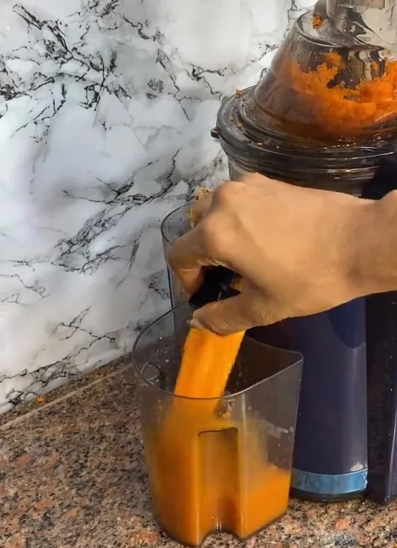 a person is using a juicer with a warning label on it