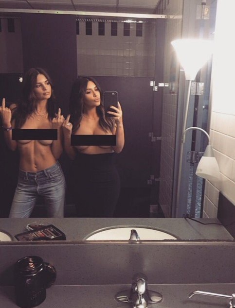 two women are taking a picture of themselves in a bathroom