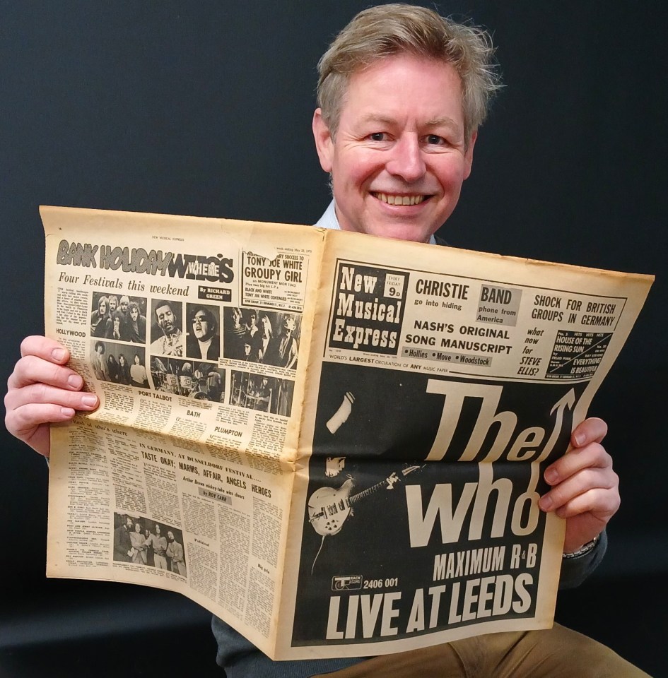 a man is holding a newspaper that says the who live at leeds