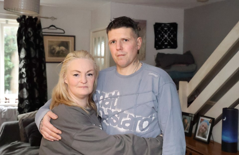 a man and a woman are posing for a picture in a living room