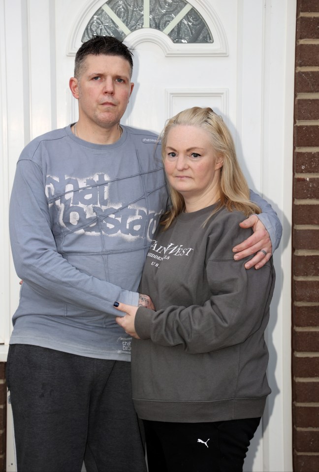 a man and a woman are posing for a picture in a living room