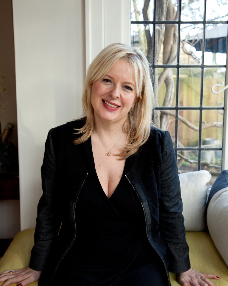 a woman in a black dress sits on a window sill