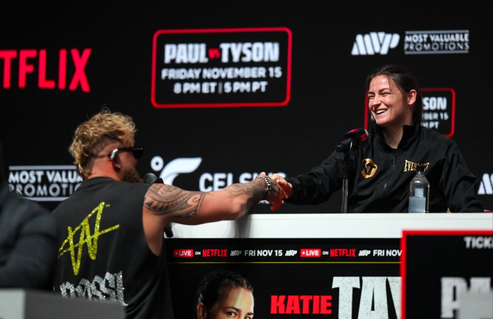 two people shaking hands in front of a sign that says paul tyson