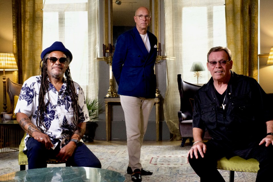 three men are posing for a picture in a living room