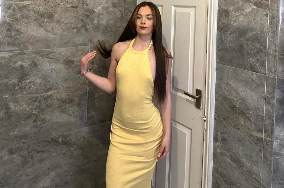 a woman in a yellow dress stands in front of a door