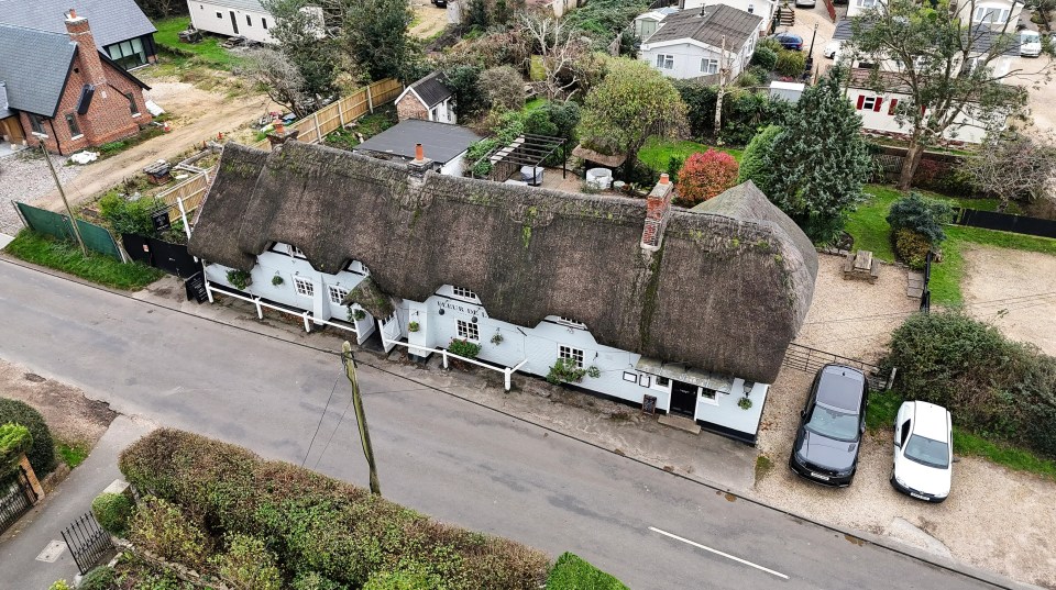 an aerial view of a thatched roofed house