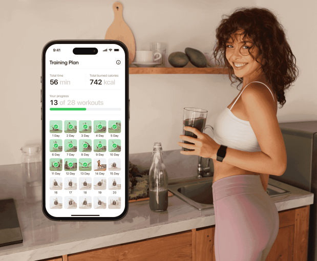 a woman holds a glass of water in front of a phone that says training plan