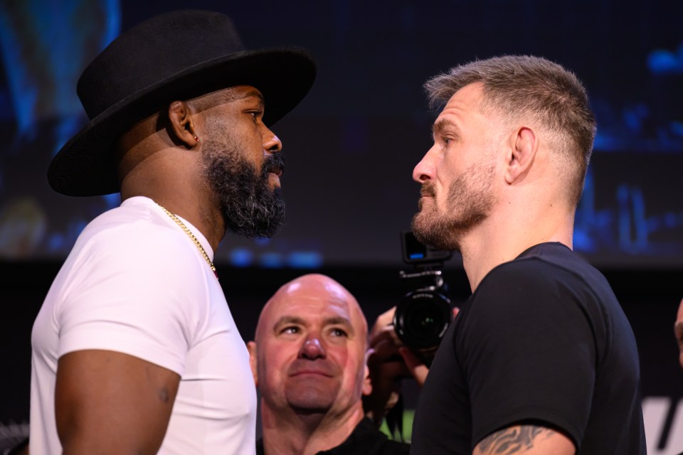 two men looking at each other with one wearing a hat