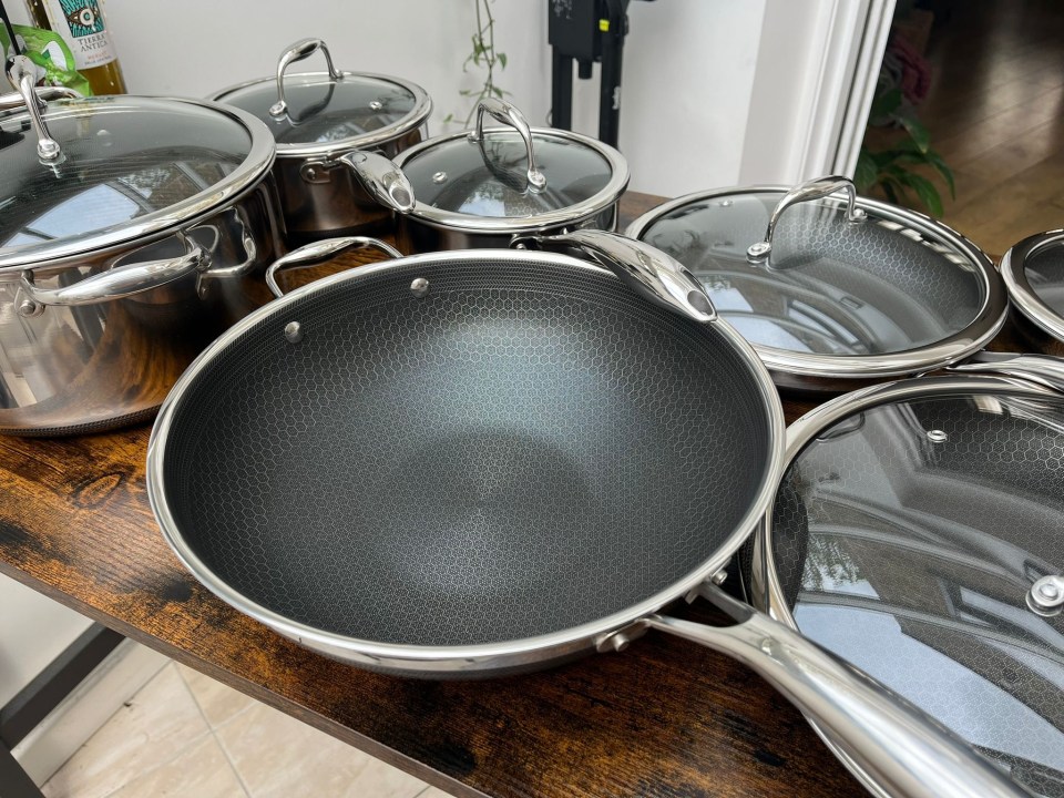 pots and pans on a table with a bottle of olive oil in the background