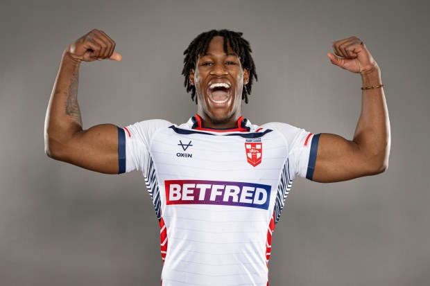 a man in a betfred jersey flexes his muscles