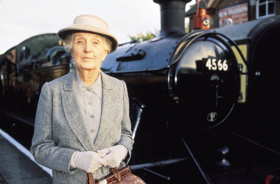 a woman stands in front of a train numbered 4566