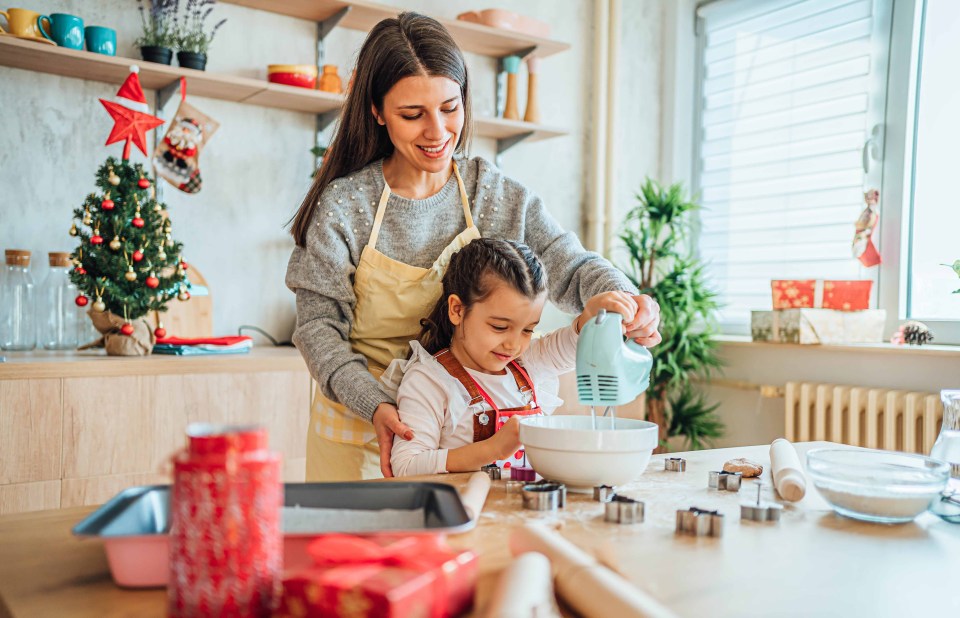 a woman and a little girl are mixing ingredients in a bowl