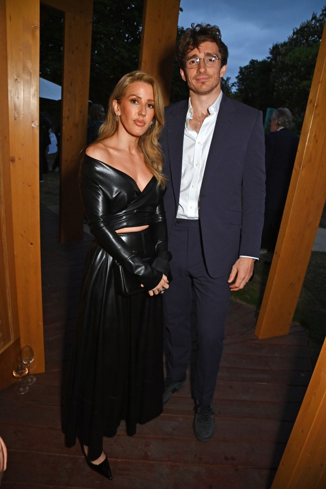 a man in a suit stands next to a woman in a black dress