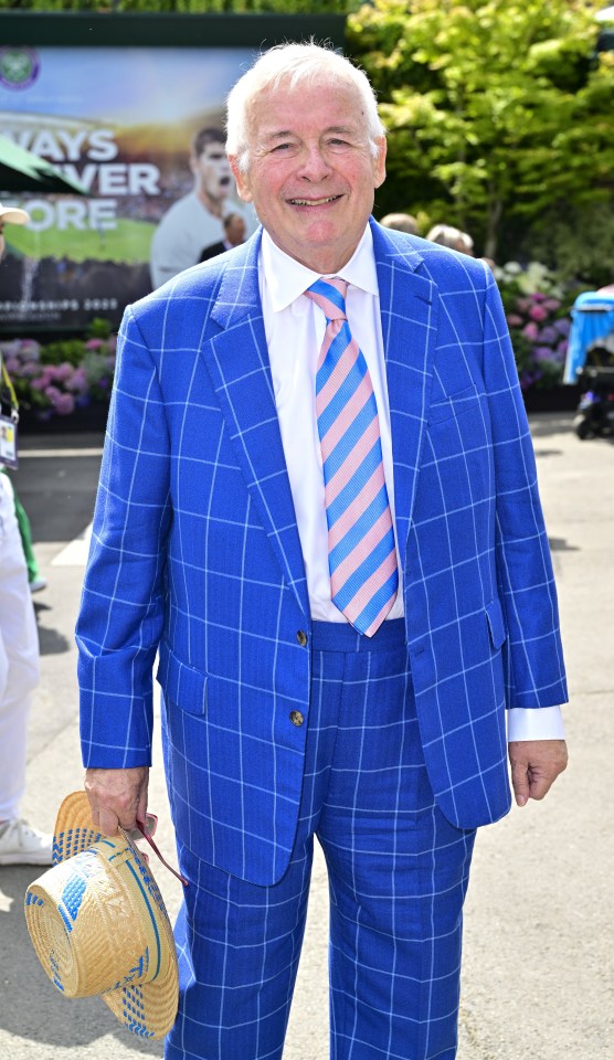 a man in a blue suit and tie holds a straw hat