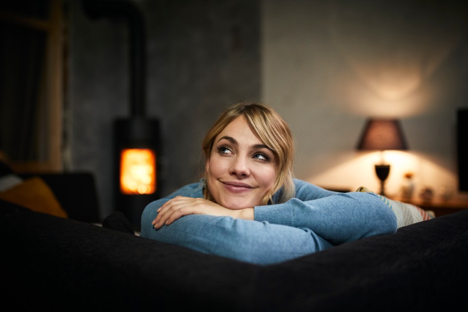 a woman laying on a couch with her head resting on her arm