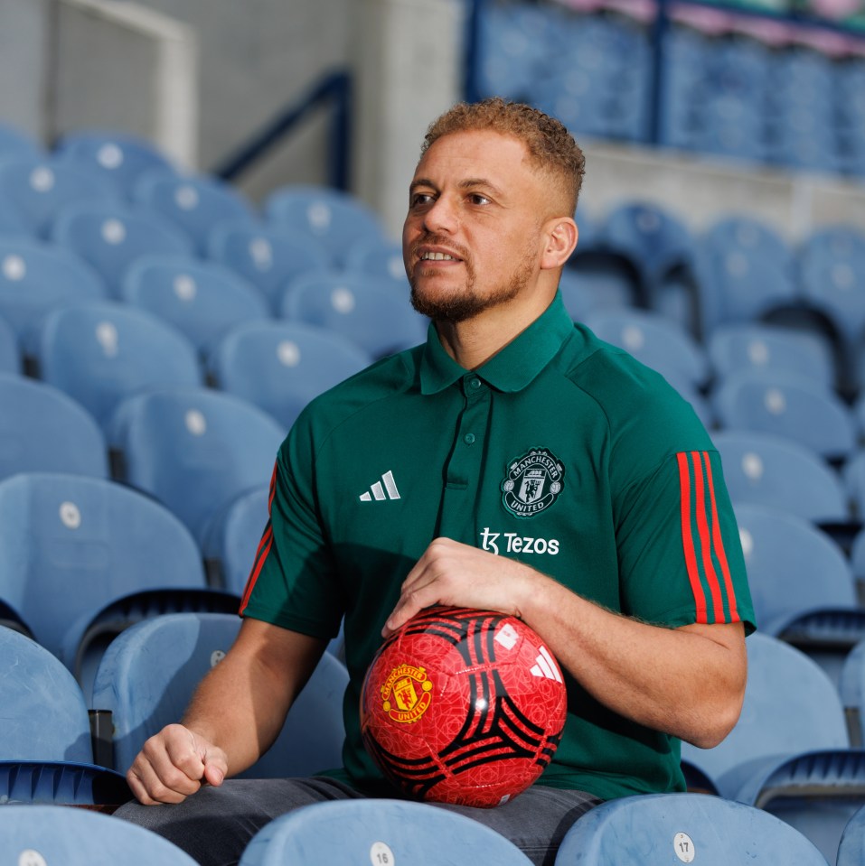 a man in a green adidas shirt holds a red soccer ball