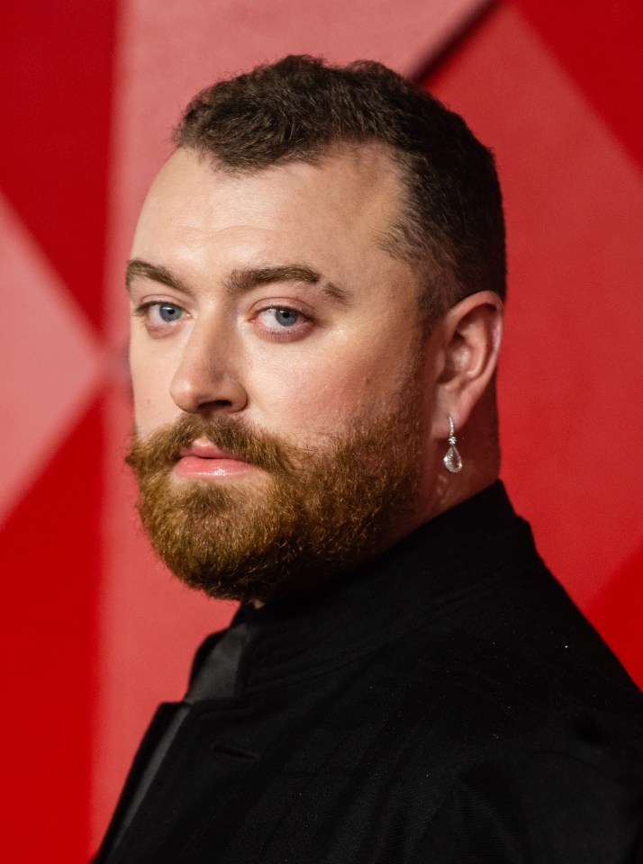 a man with a beard is wearing a pair of earrings