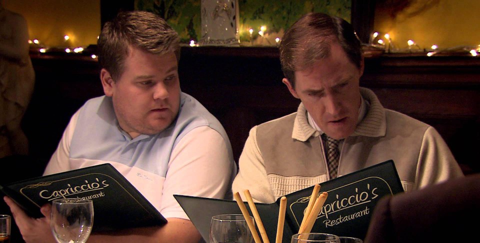 two men looking at a menu for capriccio 's restaurant