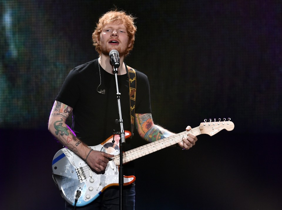 a man singing into a microphone while holding a guitar