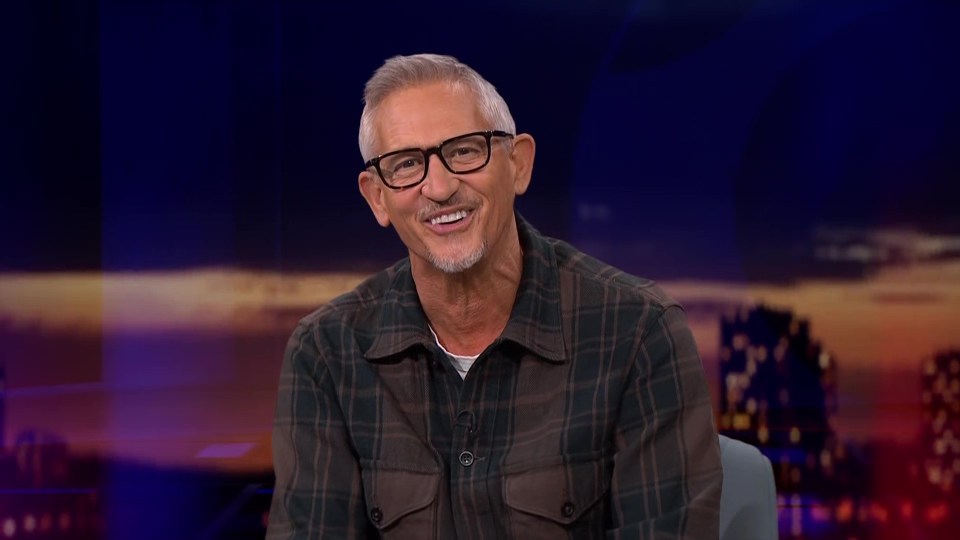 a man wearing glasses and a plaid shirt smiles for the camera