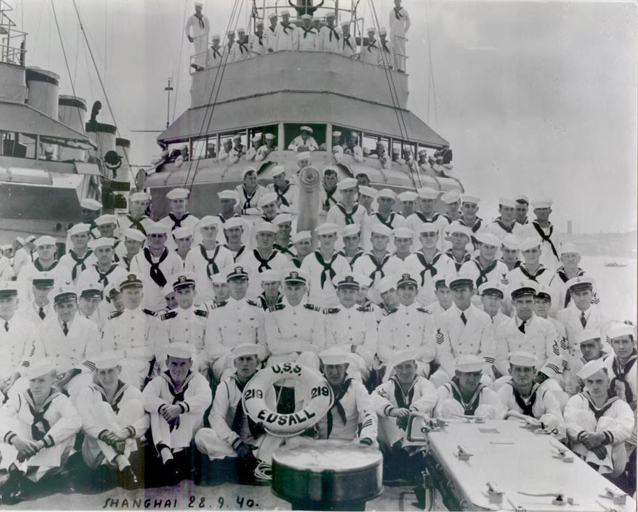 a group of sailors are posing for a photo on the deck of a ship