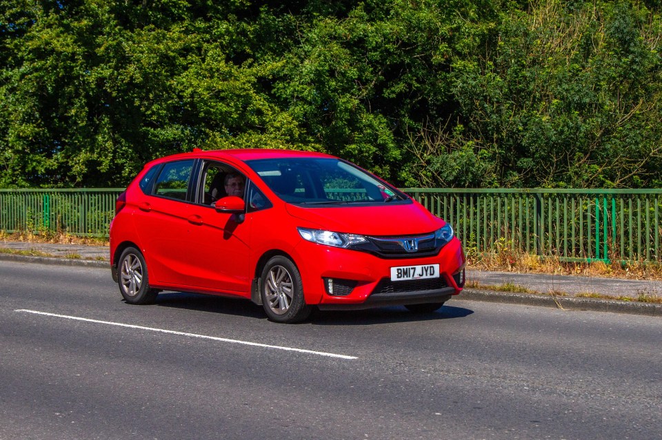 a red honda car with a license plate that says bn7 jyo