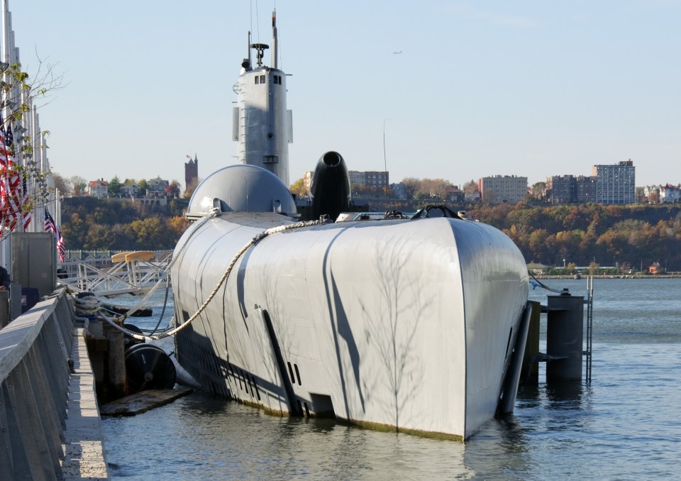 a large white submarine is docked in the water