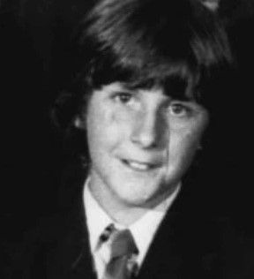 a black and white photo of a young boy in a suit and tie .