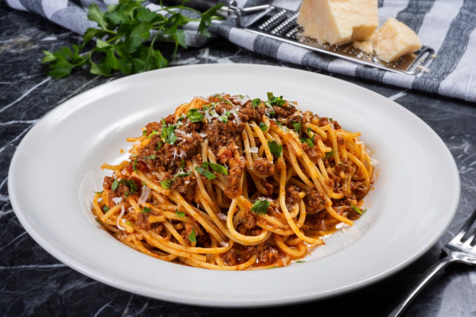 a white plate topped with spaghetti and meat sauce