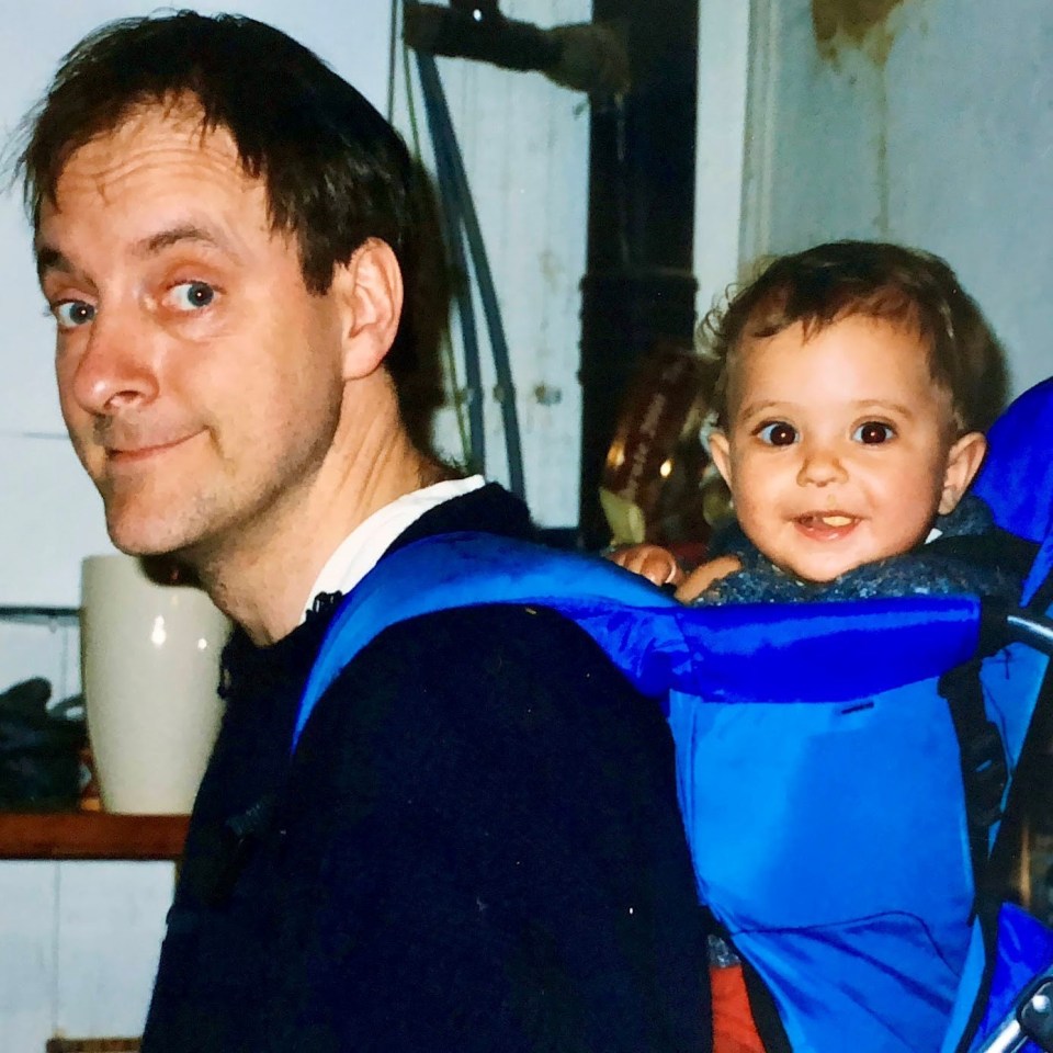 a man is carrying a baby in a blue backpack