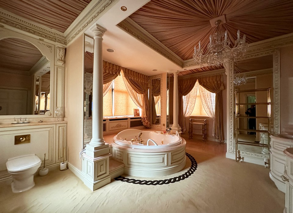 a bathroom with a large tub and a chandelier